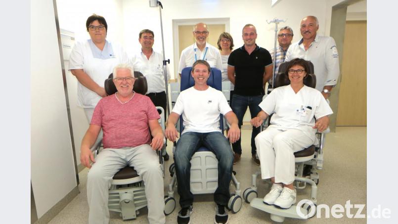 Probesitzen in den neuen Rollstühlen: Vorsitzender Andreas Wopperer (Mitte) übergab die Stühle an Chefärztin Dr. Elisabeth Bösl (rechts) und Stationsleiter Peter Graf (links). Stehend weitere Vertreter des Fördervereins und der Klinik. Bild: Hirsch