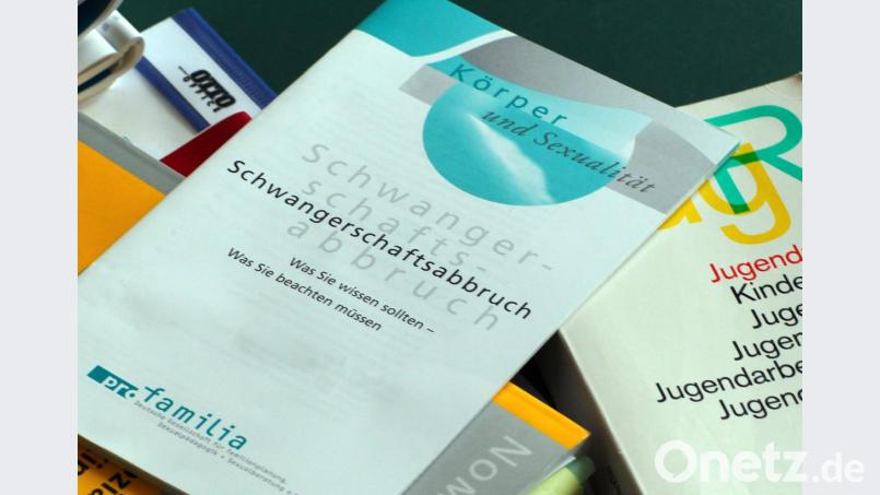Symbolbild: Bücher und Informationshefte liegen auf einem Tisch. Bild: Jens Büttner/dpa