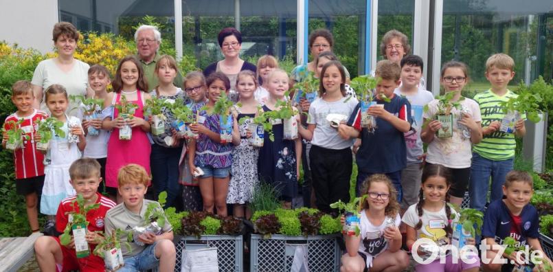 Stolz präsentieren die Mädchen und Buben der Klasse 3b zusammen mit Projektleiterin Petra Prölß, Gärtnermeister Lothar Förth (3. Reihe von links), Vertreterinnen der Elternschaft sowie Klassenleiterin Gertraud Kappl (rechts) die reiche Ernte. Bild: jpl