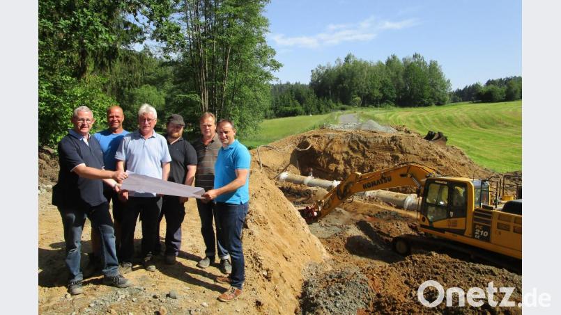 Bürgermeister Anton Kappl (rechts) informiert sich beim Durchlass der Luhe bei Ingenieur und Bauleiter Dietmar Hammerl (links) und Vertretern der bauausführenden Firmen über den Verlauf der Baumaßnahme. Im Hintergrund ist die alte Straße zu sehen. Bild: fz
