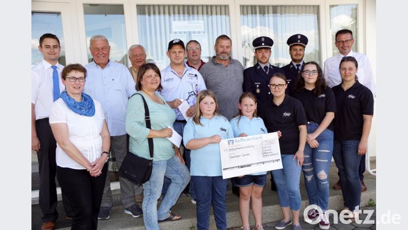 Geschäftsstellenleiter Matthias Fütterer und Raiffeisenbank-Mitarbeiterin Helga Hofweller (von links) sowie Vorstandssprecher Joachim Geyer (hinten, rechts) überreichten an die Vertreter der Vereine Anteile des Gewinnsparens (hinten, von links): Eberhard Besold, Alois Melzner, Stefanie Scherer, Thomas Moller, Thomas Hößl, Ralf Menzl, André Bauer und Christopher Buchbinder. Annemarie Zaus (vorne rechts) hatte zur Verstärkung Mitglieder der „Bunten Töne“ (links daneben und mit Scheck) mitgebracht. Bild: bkr