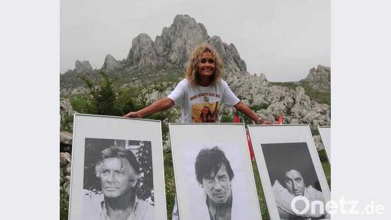 Hella Brice mit Portraits ihres verstorbenen Ehemannes vor dem Gipfelmassiv des Tulove Grede. Bild: Kunz