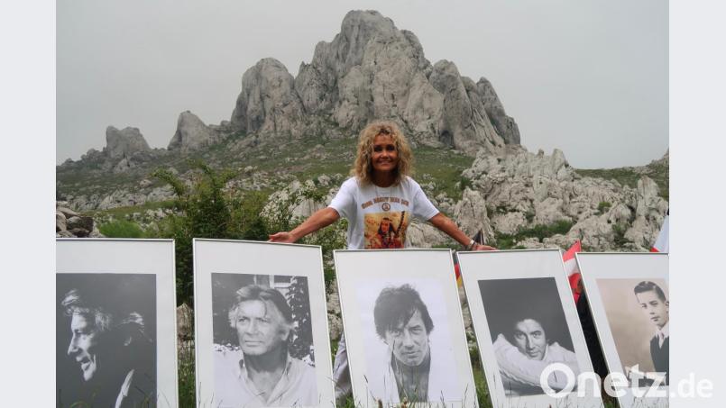 Hella Brice vor der Kulisse des Tulove Grede in Kroatien mit Portraits ihres Mannes. Bild: Kunz