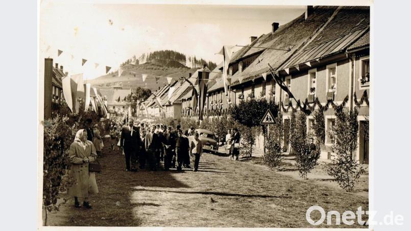 Dieses historische Bild zeigt eine Fronleichnamsprozession durch Waldeck in den 1950er Jahren. Vor der Blaskapelle gingen damals viele Schulkinder, begleitet von einem Lehrer. Fast jedes Haus hatte eine blau-weiße Fahne aufgezogen. Erst gegen Mitte des Jahrzehnts mischten sich darunter Fahnen mit den Marktfarben rot-gelb-grün. An den Häusern waren Girlanden aus Fichtenstreu angebracht und an den Fenstern im ersten Stock hängten die Bewohner rote Tücher auf. Bild: hl