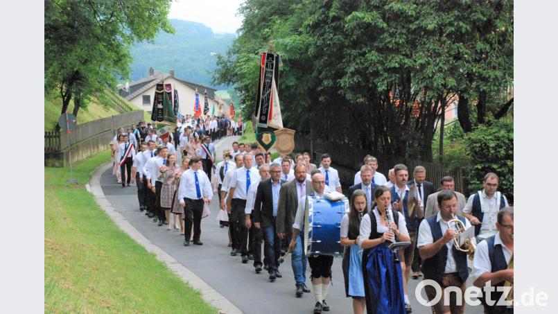 Ein farbenprächtiges Bild bietet der Kirchenzug anlässlich der 90-Jahr-Feier des Aschacher Burschenvereins. Bild: sche