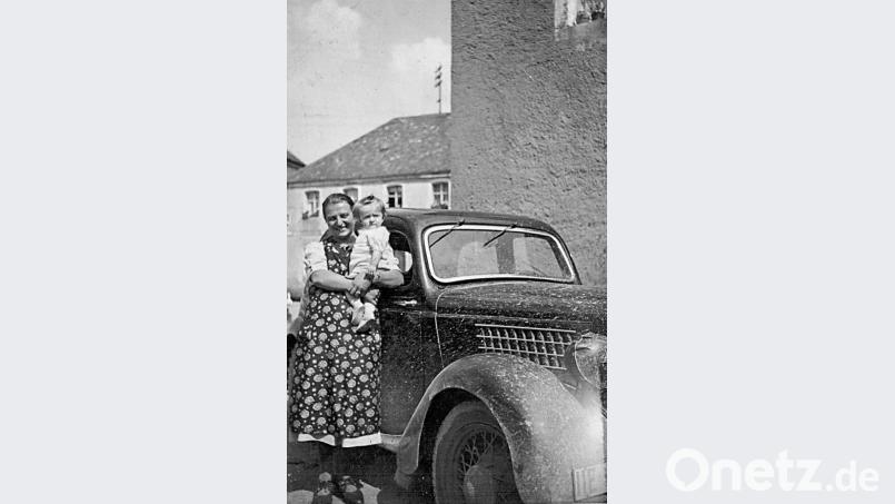 Mit einem Ford Eifel bot Zenta Dörfler - im Bild 1941 mit Tochter Resi auf dem Arm - viele Jahre Fahrten zu Fachärzten an. Zum Schutz vor Steinschlag wurden die Scheinwerfer mit Lederkappen abgedeckt. Repro: ü