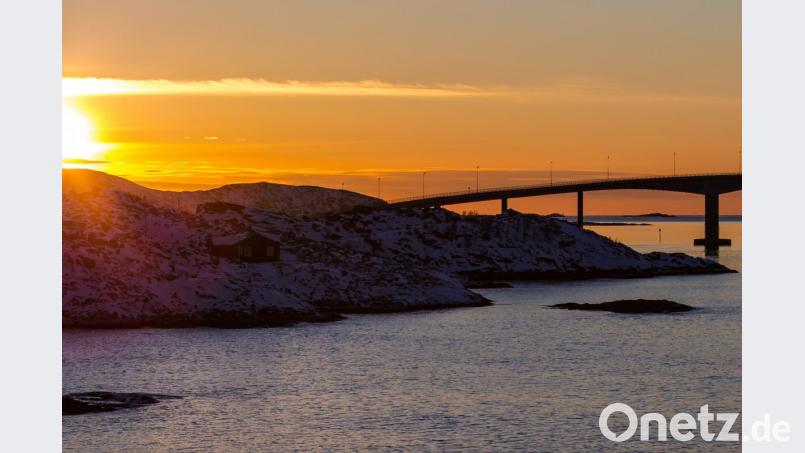 Die Sonne geht hinter der Sommaroy-Brücke unter, die die Inseln Kvaloya und Sommaroy verbindet. Bild: Hinrich Bäsemann