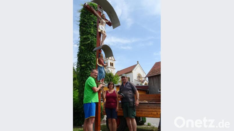 PGR-Vorsitzender Franz Grabinger (links) und die Unterauerbacher Wirtsleute Elisabeth und Michael Kiener mit dem restaurierten Opferkreuz in der Ortsmitte Unterauerbachs. Bild: ga