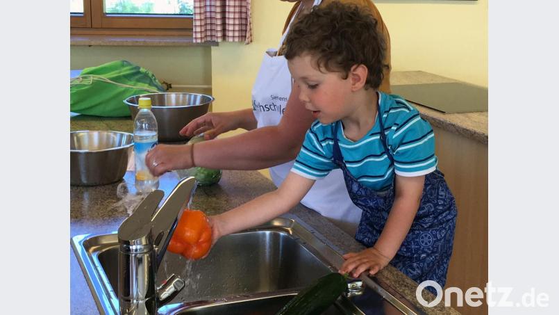Gemüse oder Obst waschen ist eine der ersten Arbeiten, die Kinder in der Küche erledigen können. Ferdinand macht das gern. Bild: ihl