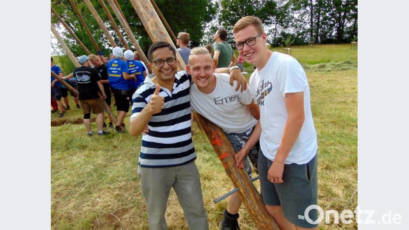 Bhim Prasad Panta (links) aus Nepal schiebt beim Aufstellen des Großenfalzer Kirwabaums kräftig mit an. Bild: fnk