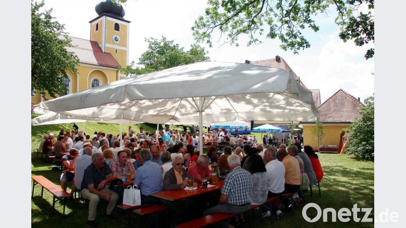 Einmal im Jahr werden im Pfarrgarten Bänke, Tische und Sonnenschirme aufgestellt. Auch heuer saß man hier an Fronleichnam gemütlich zusammen. Bild: wro