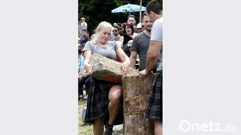 &quot;Hauruck&quot;. Mit letzter Kraft stemmte die junge Dame den bleischweren Steinbrocken auf den Holzstamm. Bild: Hirsch