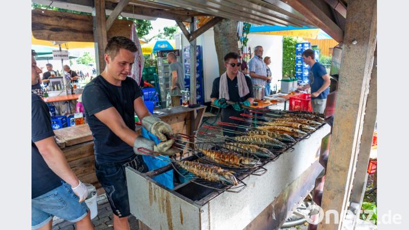 Wie immer ist es heiß am Makrelengrill. Seit Jahren kümmern sich die Jungs von der Kohle bis zum Fisch selbst um ihren Stand. Bild: sml
