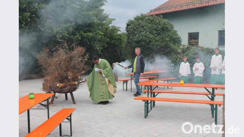 Pfarrer Julius Johnrose und Feuerwehrchef Hubert Völkl entzünden das Johannisfeuer. Bild: pi
