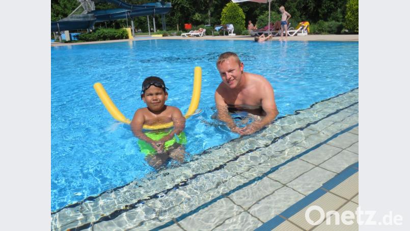 Schwimmtrainer und Vorsitzender Stefan Pelz gibt Deontoni (9) den Schwimmschlauch, eine ebenfalls brauchbare Hilfe zum Schwimmen lernen. Bild: ubb