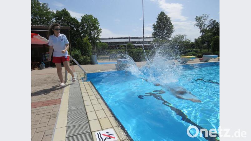 Harald Pelz springt ins Wasser, Nicole Wenisch steht am Beckenrand. Bild: ubb