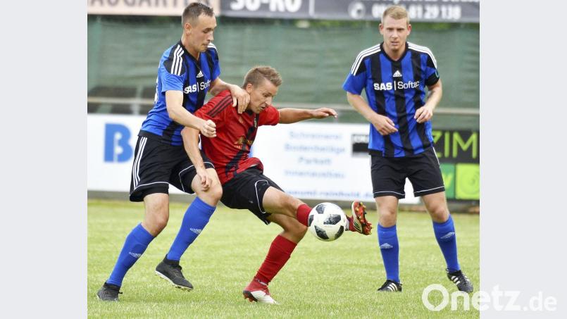 Der Ursensollener Spielertrainer Andreas Graml (Mitte) wird vom Weidener Michael Busch (links) bei der Ballannahme unter Druck gesetzt. Bild: ssl