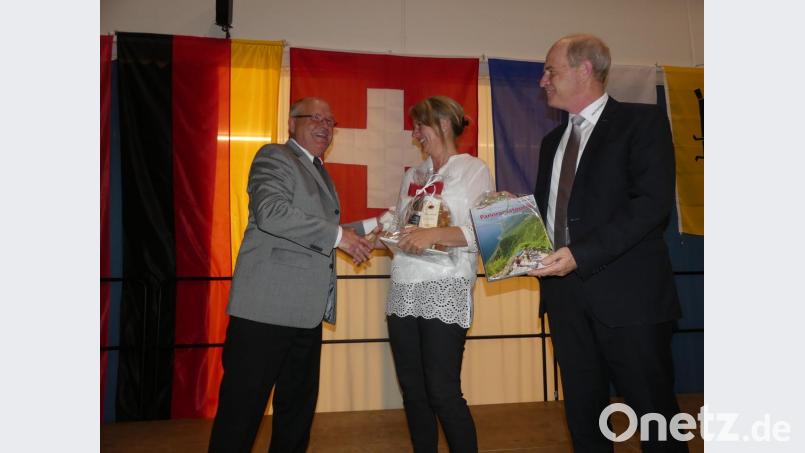 Bürgermeister Peter Lehr übergibt Gemeindepräsident Guido Portmann eine "Auswahl an zusätzlichen Bergtouren" und Esther einen Präsentkorb. Bild: rn