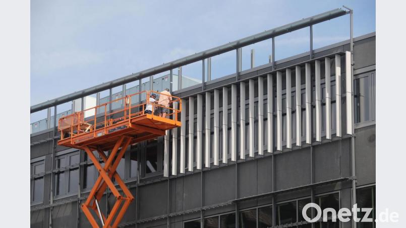 Im zweiten Obergeschoss des Nordoberpfalz-Centers in der Ringstraße startet die Montage der Keramikstelen. Rund 10000 dieser Stäbe, unterschiedlich lang, tief und schwer werden in den nächsten Monaten noch an der Fassade angebracht. Bild: Wolfgang Steinbacher