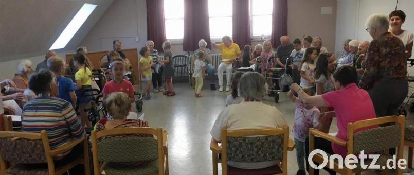 Gemäß dem „ZusammenSingen!“ lassen die Kinder des Marien-Kindergartens mit den Bewohnern des BRK-Seniorenheims St. Barbara Lieder erklingen. Bild: u