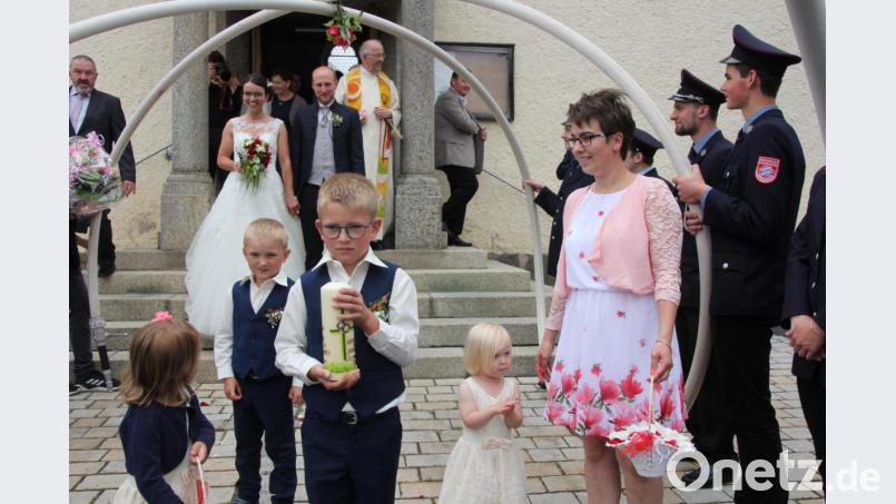 Katharina und Johannes Wölfl mit den Brautkindern beim Verlassen der Pfarrkirche St. Johannes in Großkonreuth. Dabei wurden sie von einem 24köpfigen Ehrenspalier der Feuerwehr Dippersreuth erwartet. Bild: kro