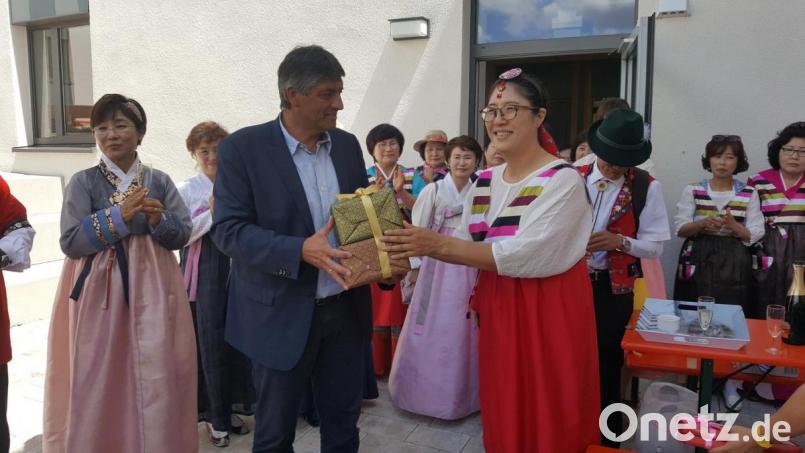 Bürgermeister Edgar Knobloch begrüßt die Gäste aus dem fernen Land. Insoog Kim, Vorsitzende des Jodelclubs "Edelweiss" überreicht ihm als Dankeschön ein Geschenk. Bild: myd