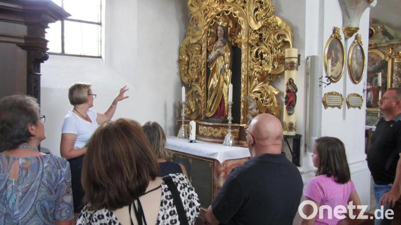Bilder und Verzierungen in Kirchen greifen häufig auf florale Motive zurück. Martina Geyer, stellvertretende Vorsitzende des Pfarrgemeinderats, lenkt den Blick darauf bei einer „Kirchenkräuterführung“. Bild: sck