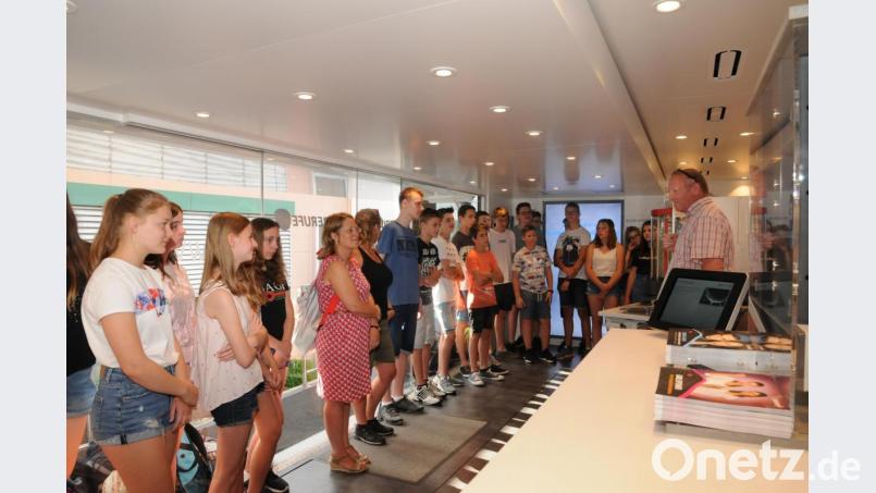 Die 8 c der Realschule Vohenstrauß mit Klasslehrerin Simone Hauer-Näger (5. von links) hatte am Mittwochmorgen den Besuch des M+EInfoTrucks auf dem Stundenplan. Helmut Zita (rechts) erläuterte den jungen Besuchern die technische Einrichtung des riesigen Fahrzeuges. Bild: bey