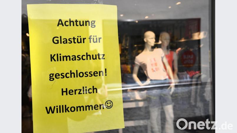 Die Türen bleiben geschlossen, damit die kühle Luft nicht entweicht. Trotzdem haben die Geschäfte geöffnet. Darauf wird in der Amberger Fußgängerzone hingewiesen. Bild: Petra Hartl
