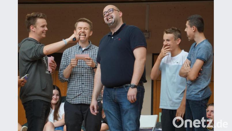 Die Lehrer Ralf Knappe und Markus Hartung (Zweiter und Dritter von links) versuchen sich im „Speak-Out“. Dabei liest einer einen lustigen Satz vor, der andere muss ihn verstehen und nachsprechen – gar nicht so einfach mit einer Art Gebissschiene im Mund. Bild: fppp