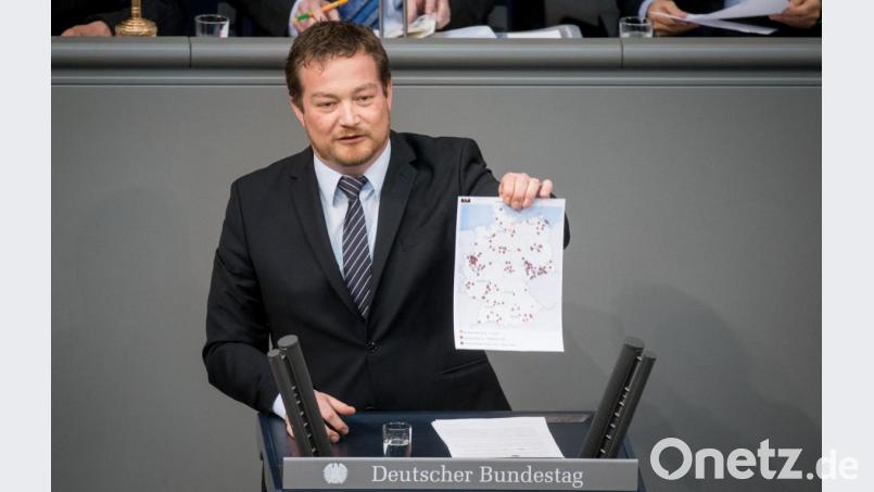 Der Weidener Bundestagsabgeordnete Uli Grötsch (SPD) zeigt bei der Debatte am 24. Februar 2016 im Bundestag eine Deutschlandkarte mit rot gekennzeichneten Orten, in denen es zu rechtsextremen Überfällen kam. Bild: Kay Nietfeld/dpa