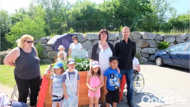 Florian Wild, Einrichtungsleiterin Ingeburg Dolles und Kindergartenleiterin Sonja Schnellinger (hinten, von rechts) freuen sich mit den Bewohnern und den Kindergartenkindern über das neue Hochbeet. Bild: Stefanie Gradl