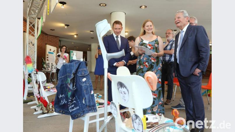 Katharina Meyer (Mitte) von der Oase Weiden führt Altbundespräsident Joachim Gauck (rechts) und Bürgermeister Jens Meyer durch die Inklusions-Ausstellung im Neuen Rathaus in Weiden. Bild: Wolfgang Steinbacher