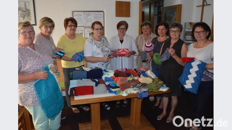 Die Damen der Strick- und Häkelrunde „Flotte Nadeln“ übergaben 80 Mützen, 75 Paar Socken, 10 Decken, Reißverschlüsse und Knöpfe sowie eine Bargeldspende an Dr. Annemarie Schraml (Mitte). Bild: jr
