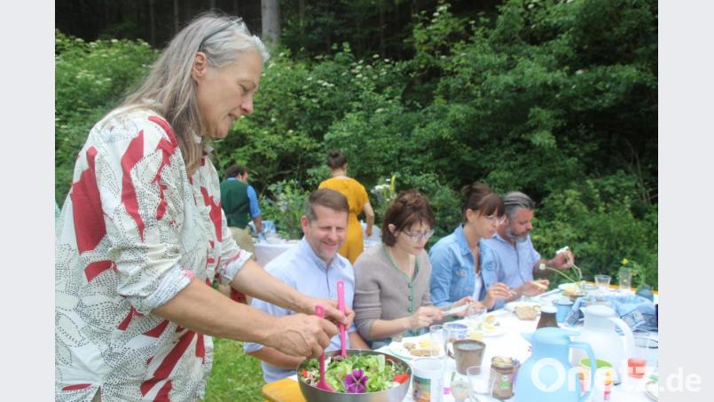 Frühstück im Grünen auf dem Demeterhof Michlbauer: Mama Brita Oeding (ganz links) unterstützt fleißig und verteilt den Salat mit Wald - und Wiesenkräutern. Bild: kmo