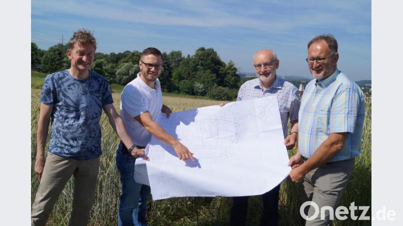 Architekt Stephan Weidenhammer, Bürgermeister Ernst Lenk, Stellvertreter Josef Robl und Ingenieur Günter Schwab (von links) präsentieren beim Ortstermin im neuen Baugebiet den Plan mit dem bereits bestehenden Kanalnetz, in das die 40 geplanten Grundstücke eingebunden werden müssen. Bild: du