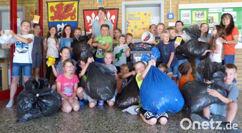 Stolz präsentieren Schüler aus allen Klassen das Ergebnis der Deckelsammelaktion an der Grundschule Illschwang. In der Bildmitte Rektorin Gabi Pirner, rechts Förderlehrerin Ingrid Koch. Bild: no