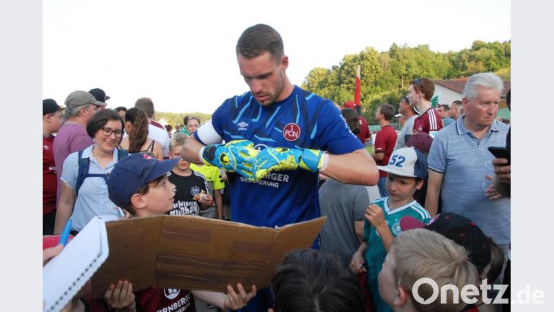 FCN-Torwart Christian Mathenia entdeckt das Schild, das der siebenjährige Ludwig (links) für ihn geschrieben hat und schenkt ihm dafür kurzerhand seine Handschuhe. Bild: gb