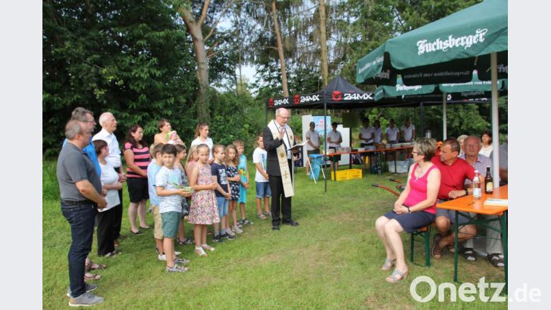 Umgeben von Vertretern aller Generationen segnete Pfarrer Herbert Rösl (Mitte) den neuen Mehrgenerationenplatz. Bild: frd