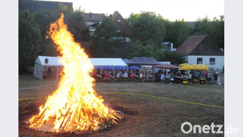 Mächtig lodern die Flammen beim Johannisfeuer der Oberwildenauer CSU und JU in den abendlichen Himmel. Die Besucher halten sich angesichts der spürbaren Hitze lieber im Hintergrund an den Biertischgarnituren auf. Bild: bey