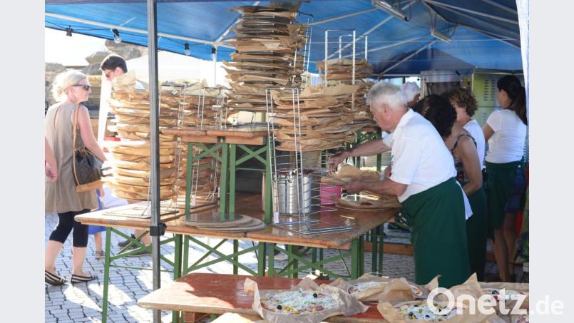 Hoch türmen sich die Pizzen auf, bevor sie von den freiwilligen Helfern belegt werden. Bild: bey