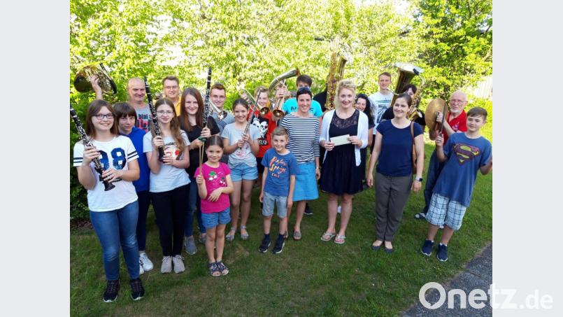 Dirigentin Angelika Schöpf (mit Spendenkuvert) erhält von Maria Rösch (links) 
und Sabine Kredler (rechts) von der Familiengemeinschaft Gebenbach den Erlös des 
Palmbuschenverkaufs. Bild: exb