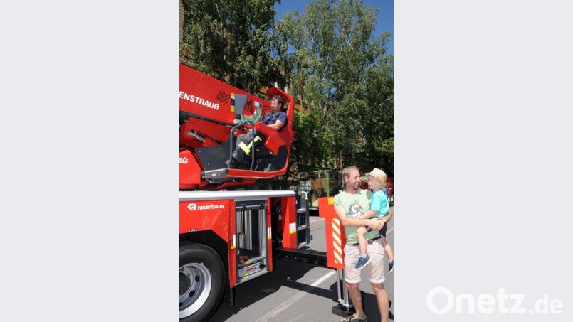 Eine Feuerwehrdrehleiter kann auch für kleine Mädchen auf dem Arm des Vaters recht interessant sein. Bild: bey