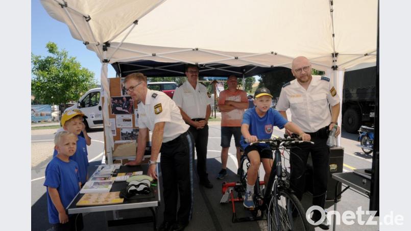 Polizeihauptmeister Wolfgang Piehler (rechts) überwacht die simulierte Fahrradtour von Thomas Schödl. Im Hintergrund beobachtet Erster Polizeihauptkommissar Martin Zehent gemeinsam mit Bernhard Schödl die Fahrt des Buben. Polizeihauptkommissar Jakob Stahl (links) erklärt die Funktion von Brillen, die den Genuss von Rauschgift und Alkohol simulieren. Bild: bey