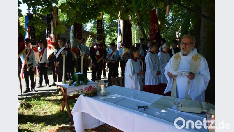 Pfarrseelsorger Pater Benedikt Leitmayr dankte in seiner Predigt den Feuerwehrleuten für ihre Einsatzbereitschaft. Der Altar war unter schattigen Bäumen aufgebaut worden. Bild: jr