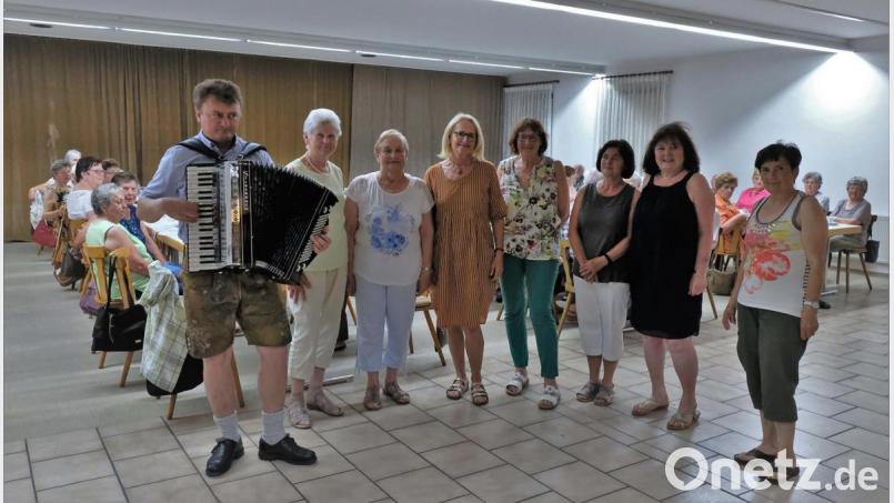 Johannes Braun spielt zünftig mit seinem Akkordeon. Gerdi Loelgen und Elfi Wicke (Vierte und Fünfte von links) mit ihrem Team organisierten den Nachmittag. Bild: twi