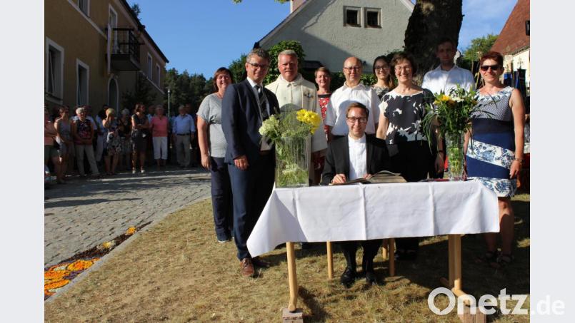 Bürgermeister Martin Birner (Zweiter von links) hatte das Goldene Buch der Stadt Neunburg mitgebracht, in das sich Neupriester Johannes Spindler eintrug. Bild: pko