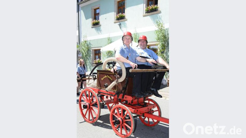 Die Nachbarwehr aus Moosbach bringt zum Festzug eine handbetriebene Pumpe mit. Bild: bey