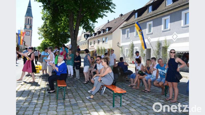 Die Festzugbesucher suchen sich, wie hier am Marktplatz, schattige Plätze. Am Marktplatz war auch eine Getränkeausgabe für die Festzugteilnehmer. Bild: bey