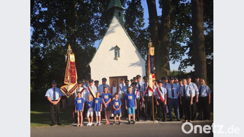 An der Segnung der restaurierten Fahne der Feuerwehr Kötzersdorf (rechts) durch Stadtpfarrer Konrad Amschl (Mitte vor der Haunritzer Kapelle) beteiligen sich auch die Kameraden vom Patenverein aus Höflas (links). Bild: jzk